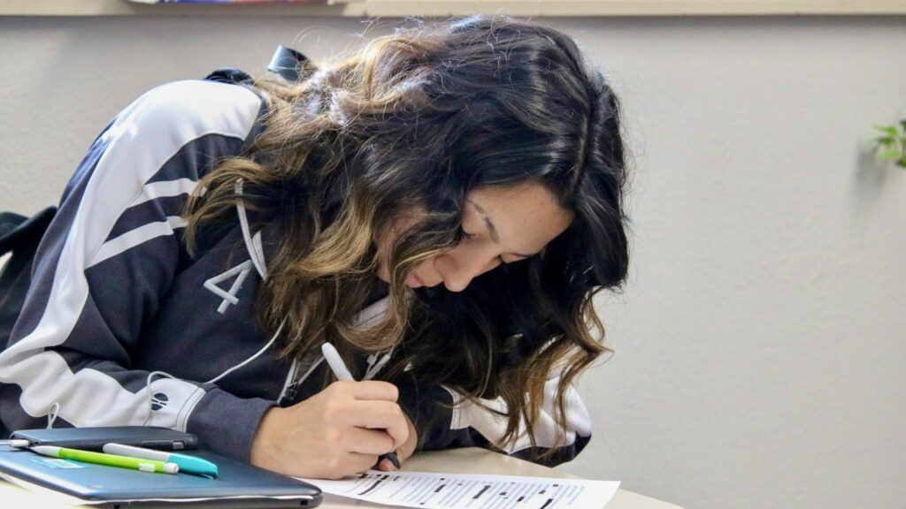 A girl writes on a piece of paper