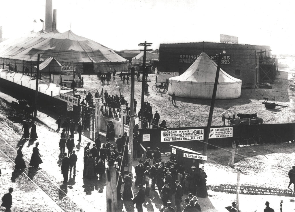 Black and white photo of fair grounds with several large tents.