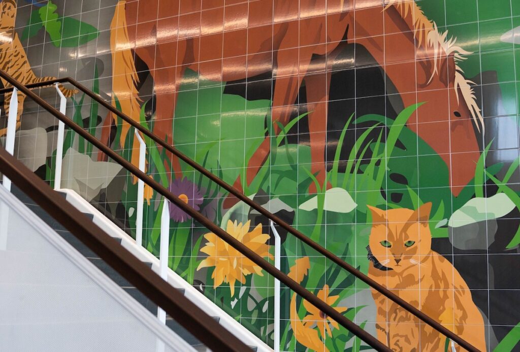 Part of a ceramic tile mural depicting a cat and a horse.