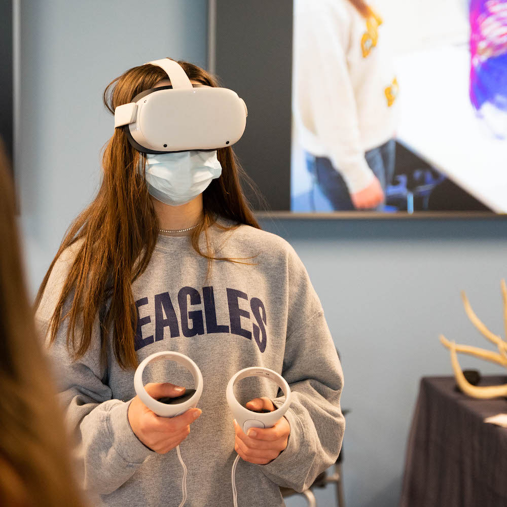 Girl in a sweatshirt and VR goggles.