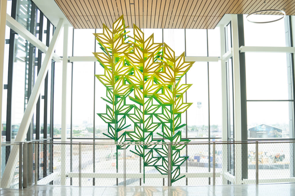 Art piece of green and yellow geometric leaf shapes.