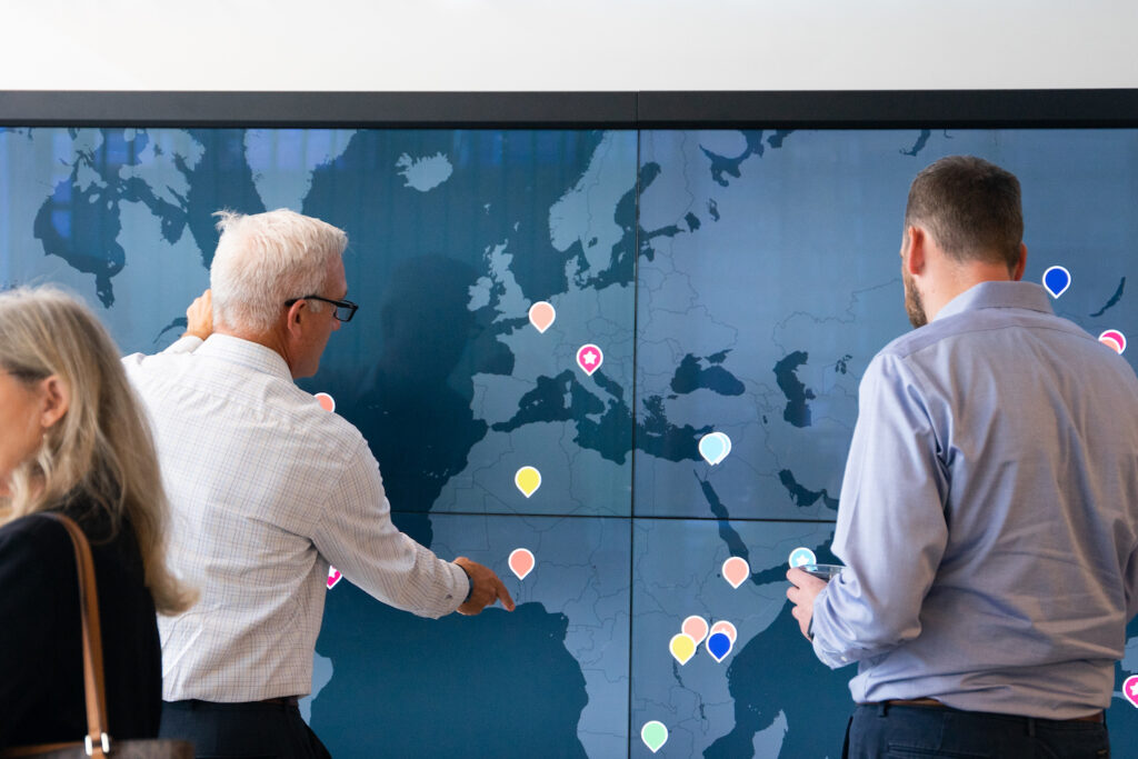 Two people interact with a large touch screen map.