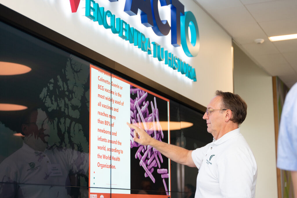 A man touches a large wall-mounted touch screen.