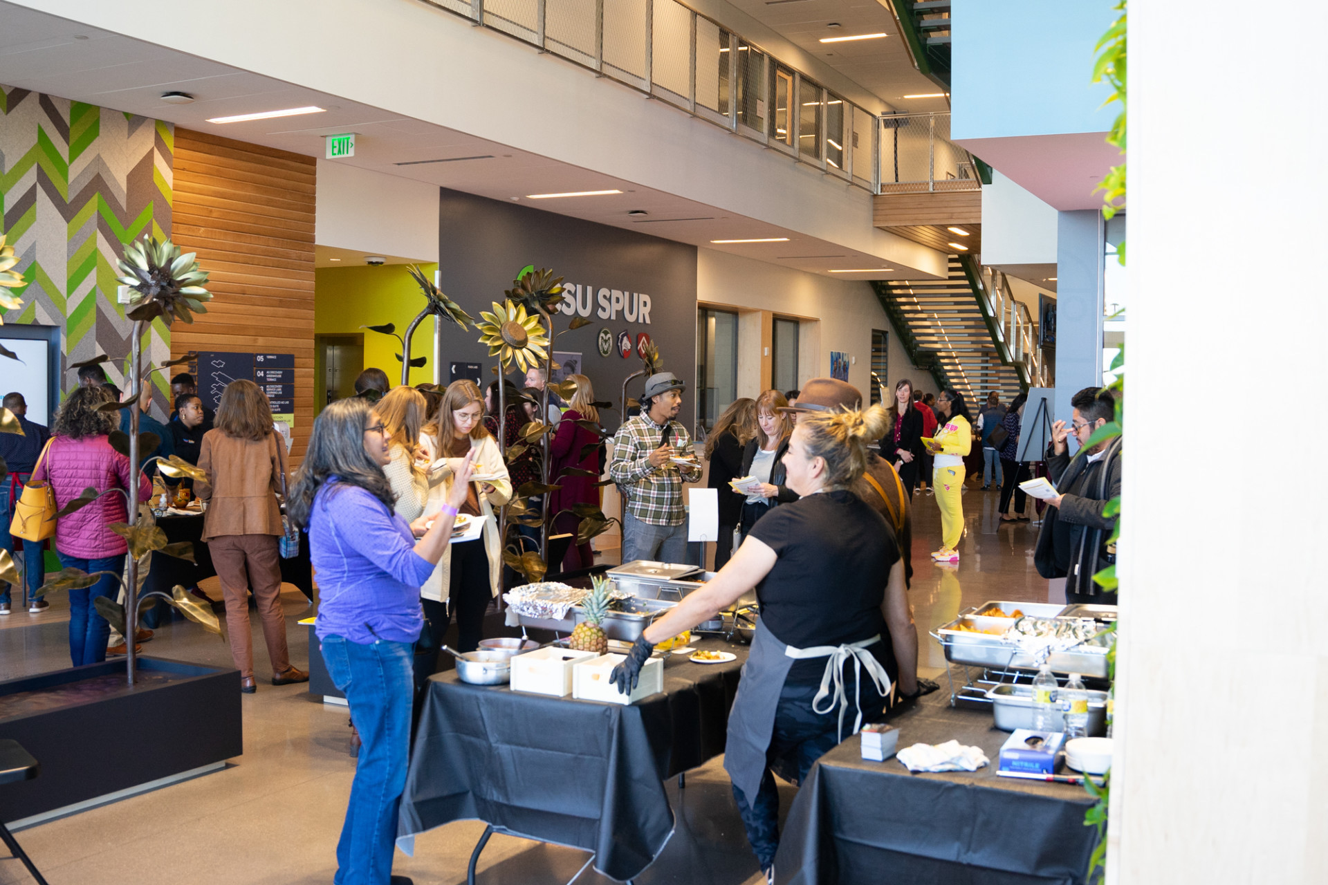 A crowd stands in a building lobby.
