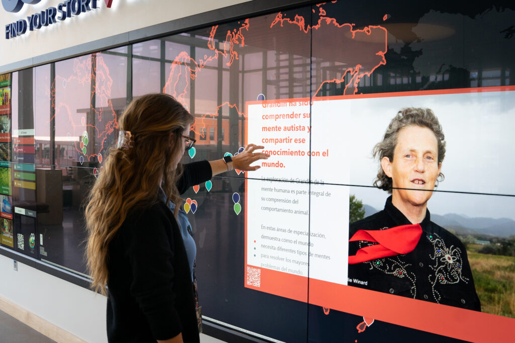 A woman interacts with a large touch-screen map.