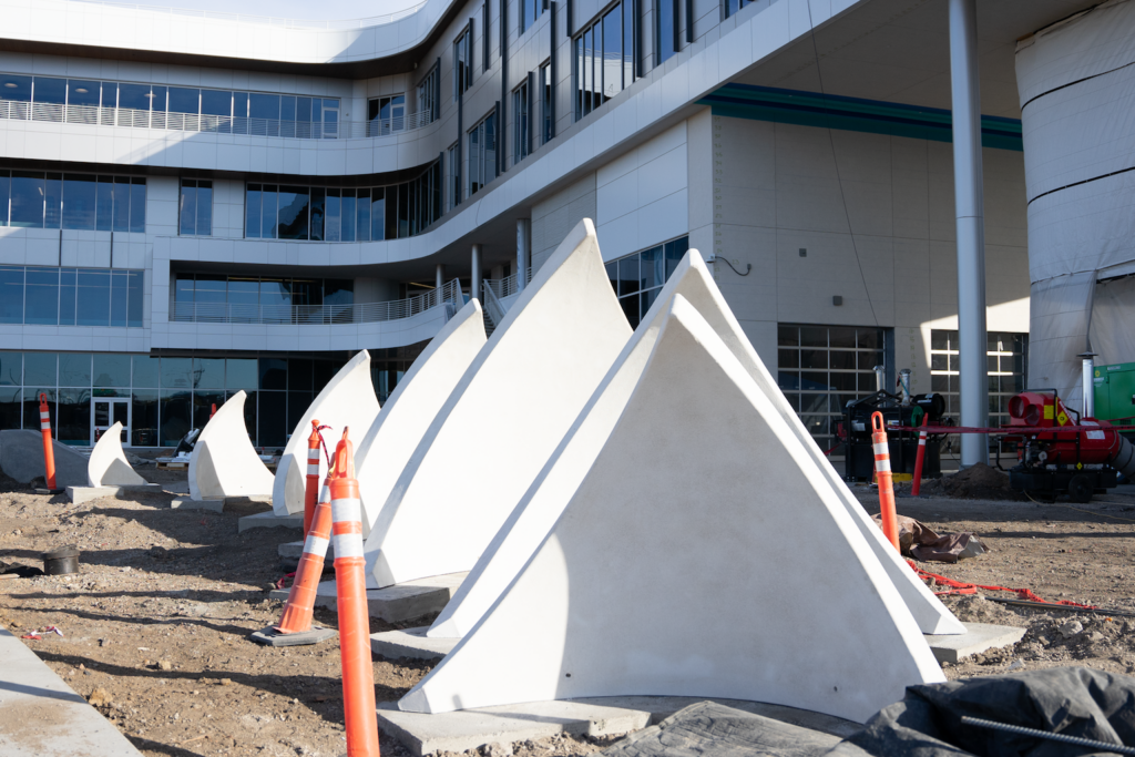 Large white triangular concrete structures stand in a row.
