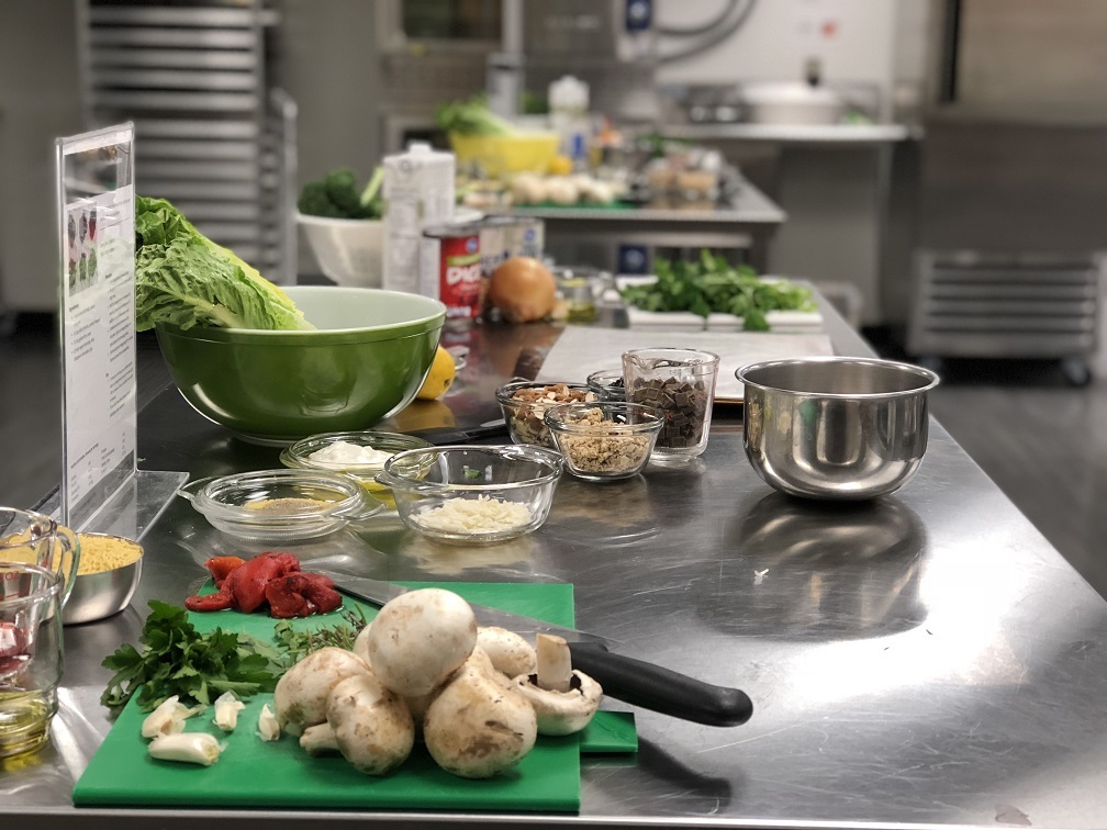 Food and dishes ready for prepping on a stainless steel counter.