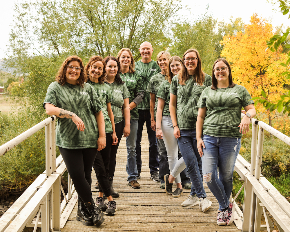 Group photo with matching shirts standing on a bridge.