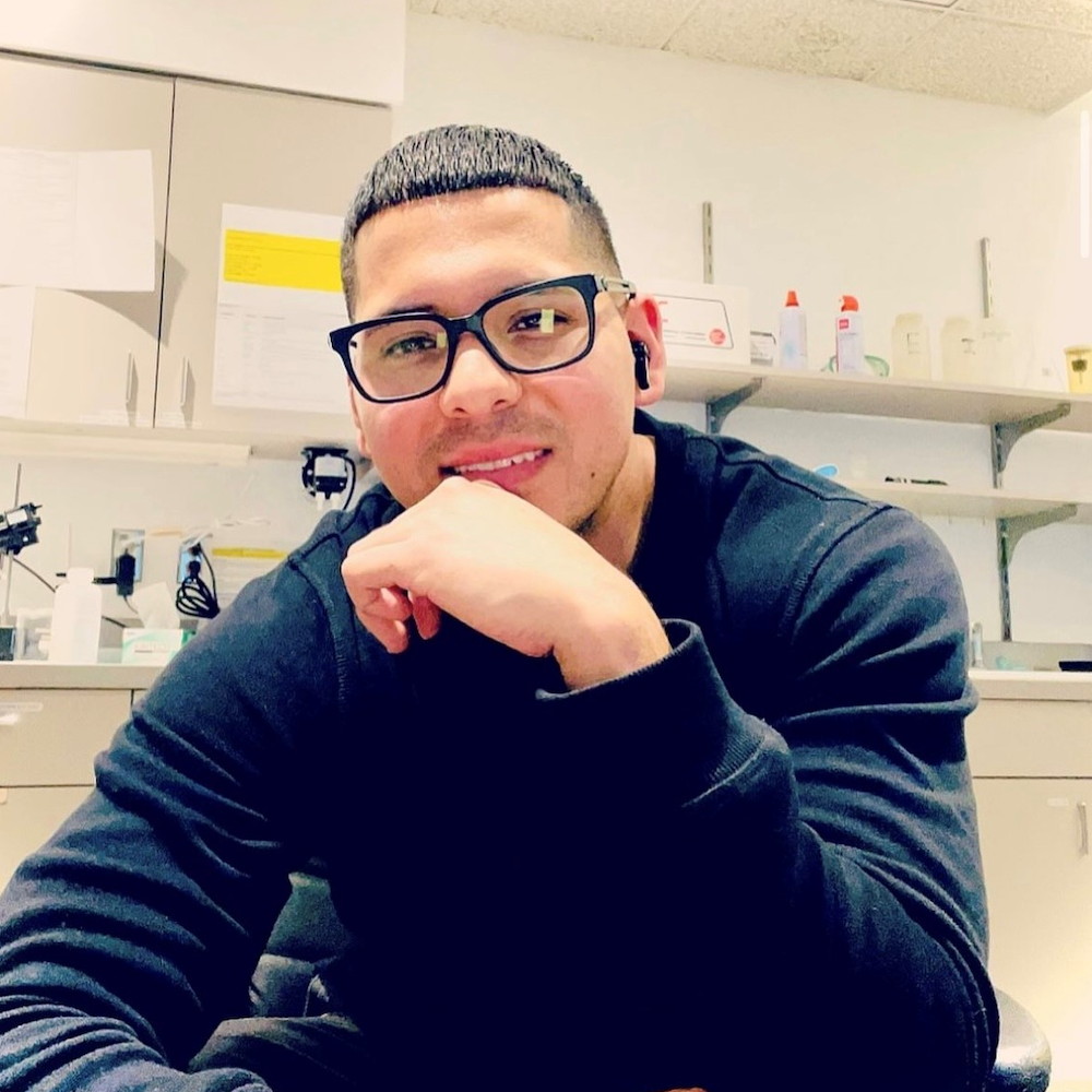 Man in a lab wearing a black sweatshirt.