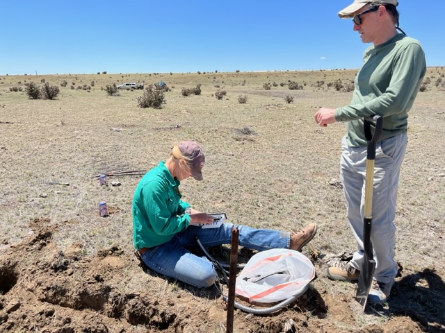 Two people collect soil samples.