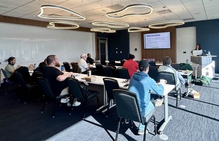Students at long tables in a classroom.