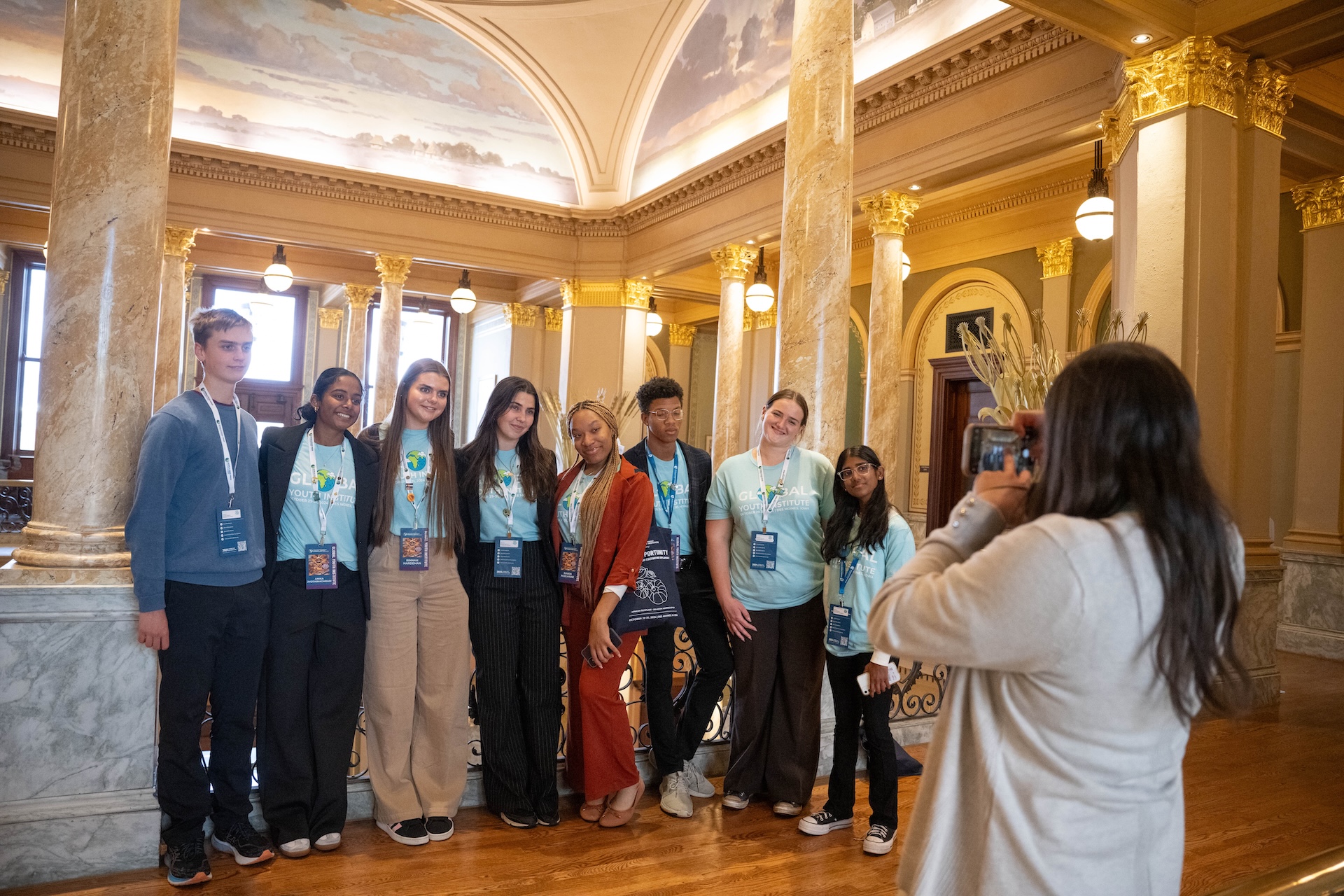 Group photo in a large gold atrium space.