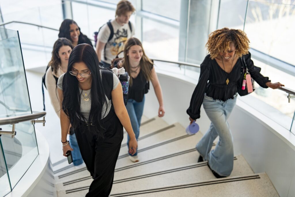 Six students walk up a set of spiral stairs.