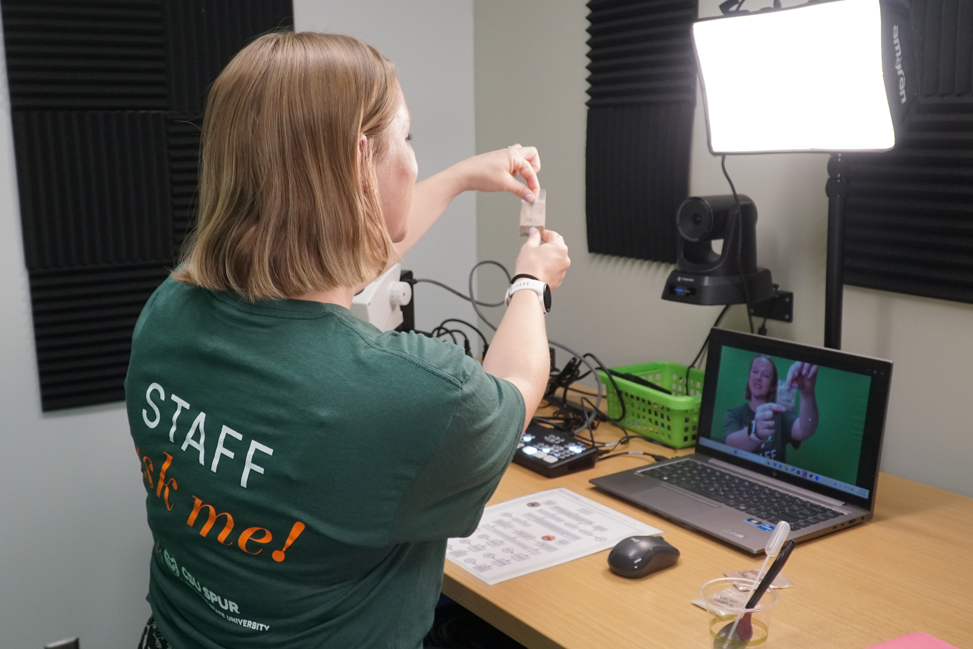 A woman in a Spur staff t-shirt demonstrates something on a screen.